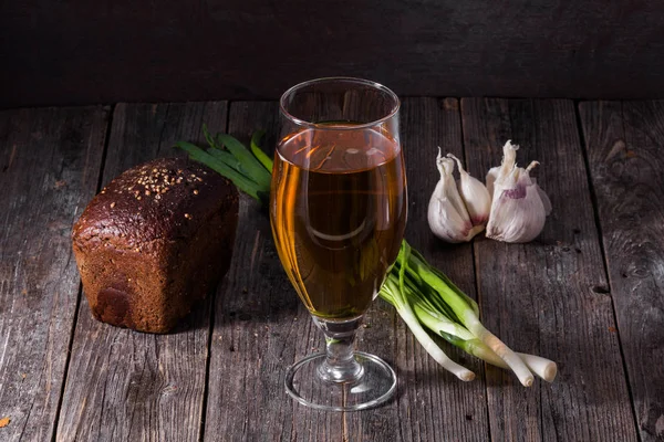 Szklanka piwa lekkie, bochenek chleba czarny, świeże zielone cebule — Zdjęcie stockowe