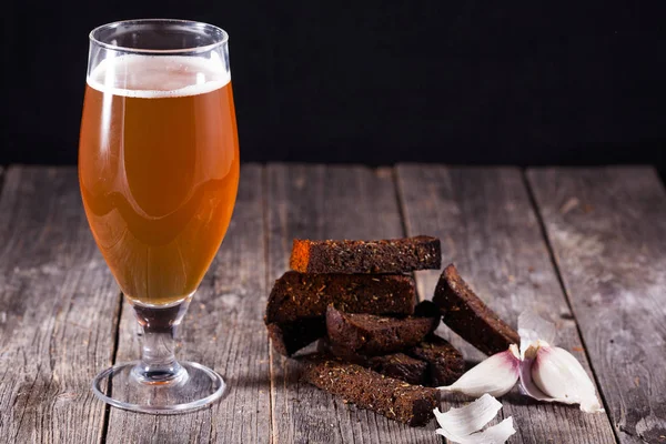 A glass of light beer and fried hot aromatic garlic toasts of bl — Stock Photo, Image