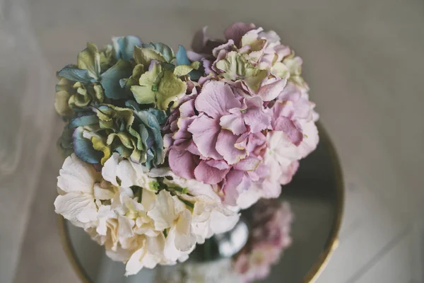 나무 바닥으로 미러 테이블에 화려한 꽃의 꽃병 — 스톡 사진