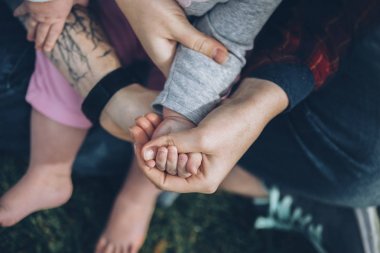 Çocuk babası parmak anne elle çim ile arka plan üzerinde tutuyor