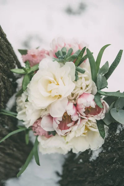 Wedding bouquet between trees with snow — Stock Photo, Image