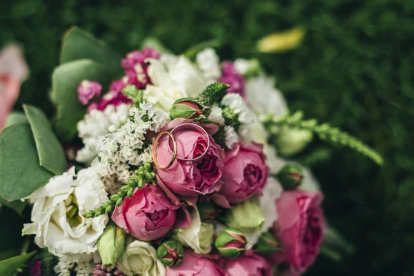 Wedding bouquet with rings on the grass — Stock Photo, Image