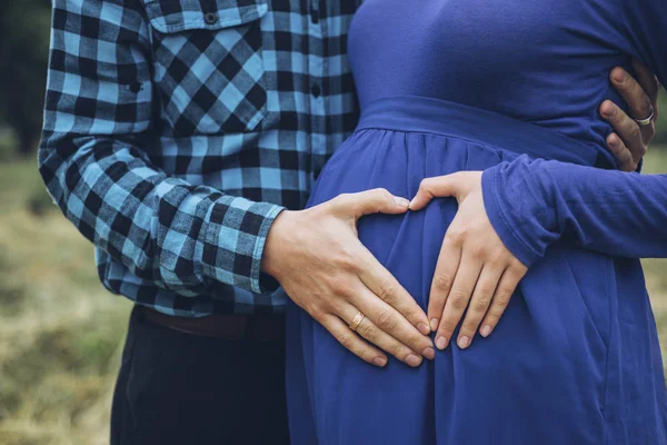 Casal grávida segurando barriga com coração — Fotografia de Stock