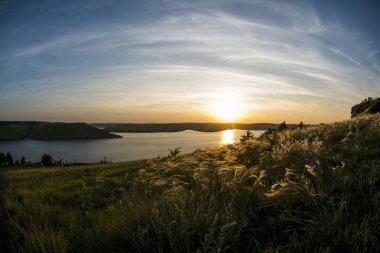 Güzel gün batımı turuncu ve mavi gökyüzü ile Nehri yakınında alan bakota üzerinde