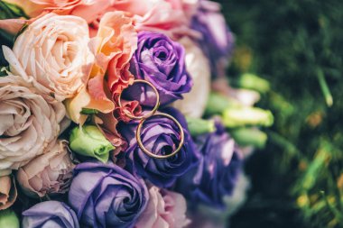 damat düğün buket turuncu bej pembe mor mor eflatun çiçekler ve yüzük yeşil çimenlerin üzerinde