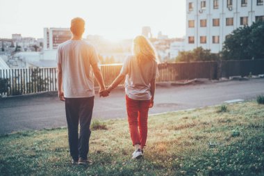 Elele ve birlikte gri gömlek şehirde güneş bakarak kalan bir çift