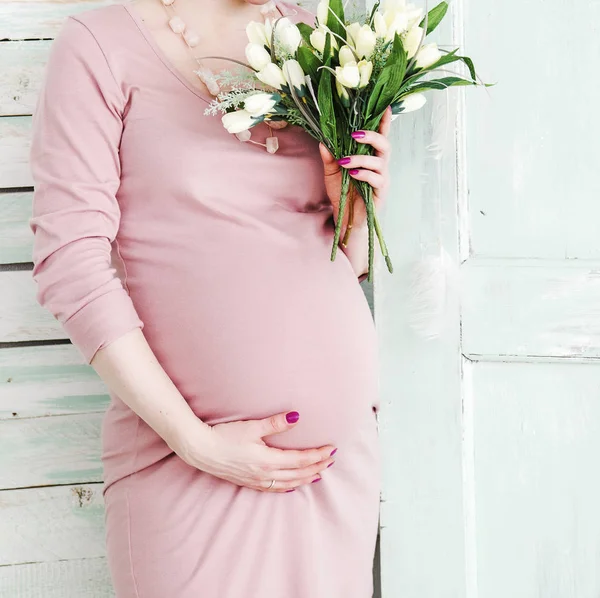 Красивая Беременная Женщина Животом Розовом Платье Тюльпаном Ухо Деревянная Стена — стоковое фото