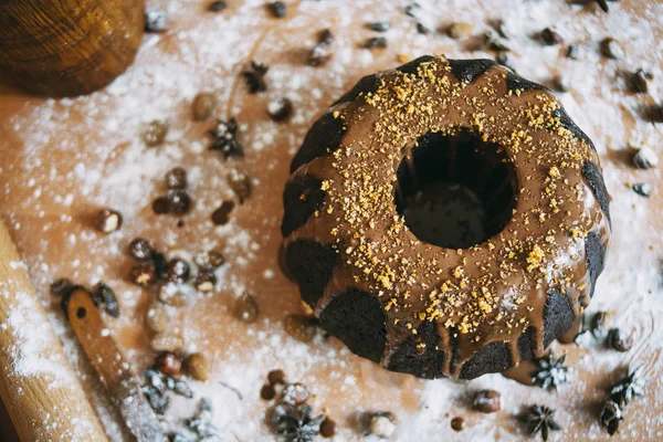 Μαύρο Κέικ Πάνω Στο Ξύλινο Τραπέζι Ξηρούς Καρπούς Και Άχνη — Φωτογραφία Αρχείου