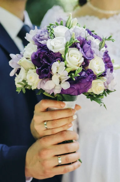 新郎新婦は結婚式のブーケ ホワイト ベージュとライラック紫花を取っているとゴールデン リング ブルー ジャケット — ストック写真