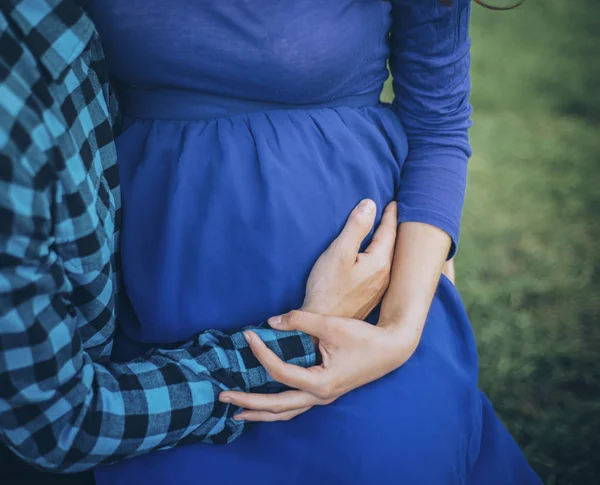 Беременная пара держит живот — стоковое фото