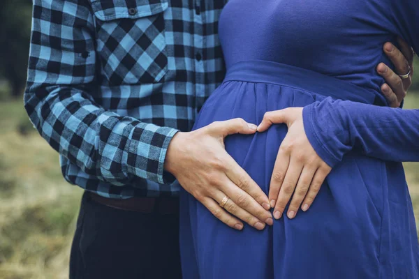 Těhotná pár hospodářství břicho se srdcem — Stock fotografie