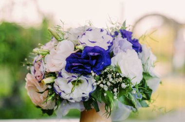 güneşli bir elinde bej beyaz mor çiçekler buket düğün 