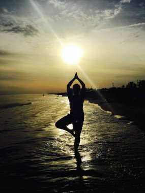 Deniz günbatımı zamanında yoga egzersizleri