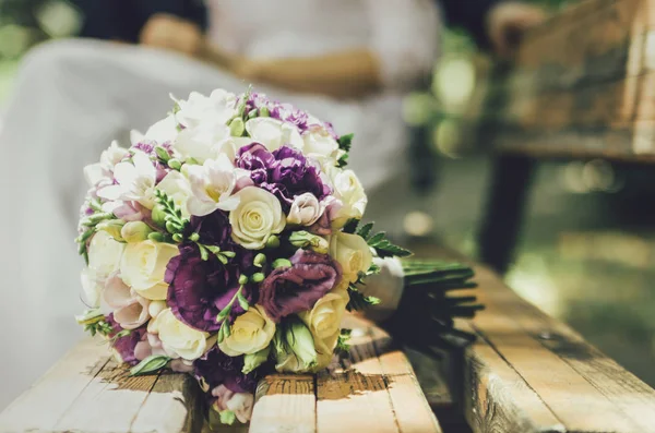 結婚式のベンチにベージュの白いスミレの花の花束 — ストック写真