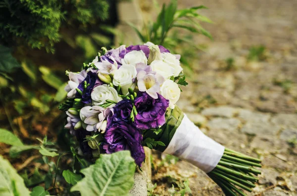 Svatební kytice béžová bílá fialové květy na zem clos — Stock fotografie