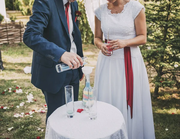 Pareja de boda con arena de colores en el parque con botellas y gl — Foto de Stock