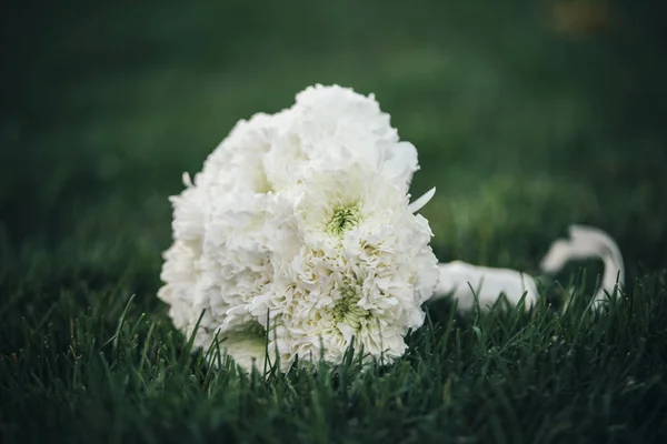 Weißer Hochzeitsstrauß liegt auf dem Gras — Stockfoto