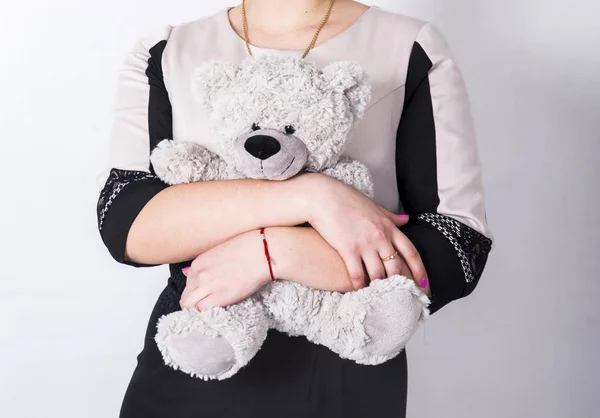 Ursinho de pelúcia brinquedo em mãos de menina em vestido bege e preto — Fotografia de Stock