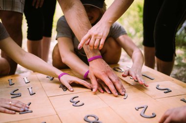 Group of people playing a game with numbers teambuilding hands c