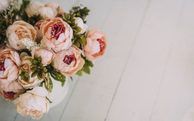 Açık ahşap funda yeşil yapraklı güzel bej çiçek buketi.