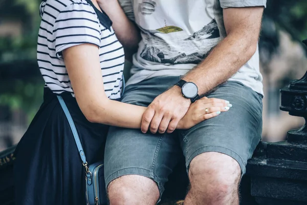 男は座って腕時計と小さな青い袋で女の子の妻を抱きかかえている — ストック写真