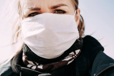 Coronavirus 'tan koruyucu tıbbi maskeli ciddi üzgün kadın. Virüs haberleri için ciddi bir yüzleri var. Salgın virüs belirtileri.