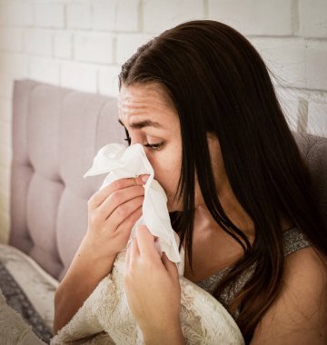 Moda tarzı, siyah tıbbi maskeli, beyaz arka planlı, sıkıntılı genç bir kadın. Coronavirus covid 19 salgın hastalık konsepti. İnsanlar korunmak için maske takıyor. Kapat.