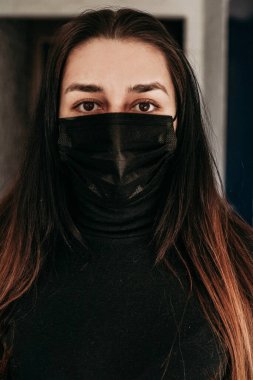 Moda tarzı, siyah tıbbi maskeli, beyaz arka planlı, sıkıntılı genç bir kadın. Coronavirus covid 19 salgın hastalık konsepti. İnsanlar korunmak için maske takıyor. Kapat.