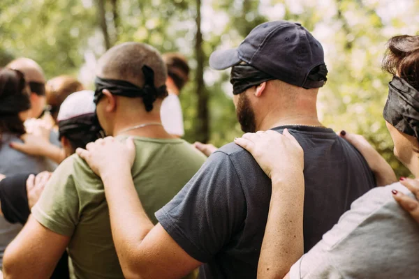 Primer plano de las personas con los ojos vendados ejercicio de team building — Foto de Stock