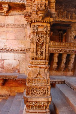 Bir sütun, oyma taş tıklatarak duvar ayağı. Adalaj Stepwell