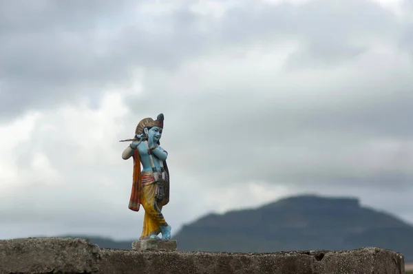 Krishna Idol met bewolkte hemelachtergrond — Stockfoto