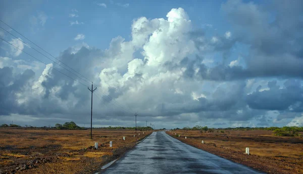 Strada bagnata con nuvole scure durante il monsone — Foto Stock