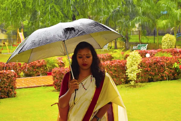 Індійська дівчина в Сарі гуляти під дощем з парасолькою, Пуне, Махараштра — стокове фото