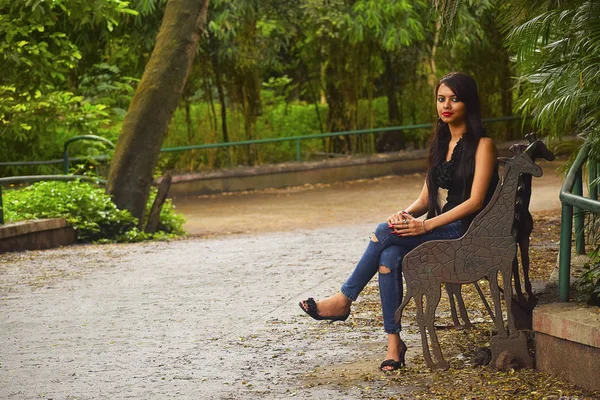 印度女孩在公园的长凳上就座, 浦那, 马哈拉施特拉邦. — 图库照片