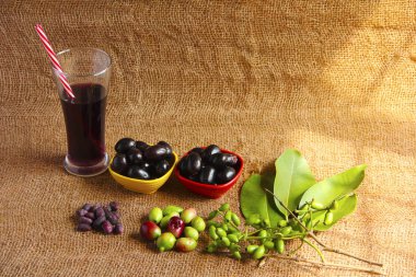 Jamun juice glass and bowls of Jamun fruit or black plum, raw Jamun fruits, leaves and seeds  clipart