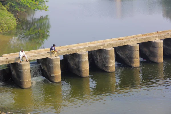 CHINCHWAD, PUNE, MAHARASHTRA, ÍNDIA, dezembro de 2017, Dois homens sentam-se em uma pequena ponte sobre o rio — Fotografia de Stock