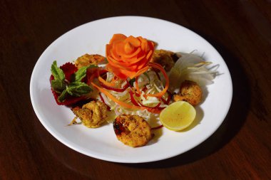 Bir tabak kızarmış karides ve salata