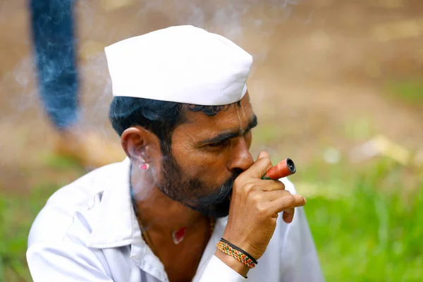 PUNE, MAHARASHTRA, ÍNDIA, Junho de 2017, Tradicionalmente vestido homem fuma durante o festival de Pandharpur — Fotografia de Stock