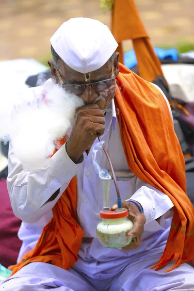 PUNE, MAHARASHTRA, INDIA, junio de 2017, El hombre tradicionalmente vestido fuma durante el festival de Pandharpur —  Fotos de Stock