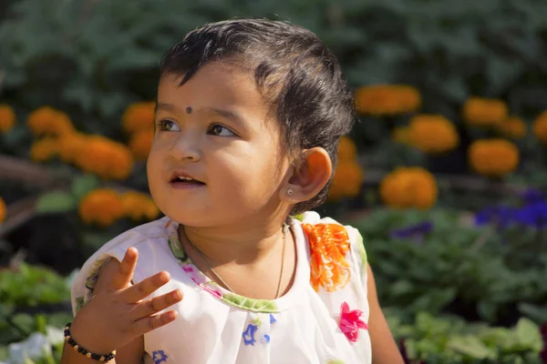 Niña jugando en el jardín mirando a la cámara, Jardín de la Emperatriz, Pune — Foto de Stock