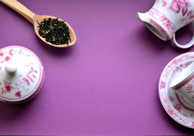 Seramik çay seti ve bir tahta kaşık çay yaprakları ile