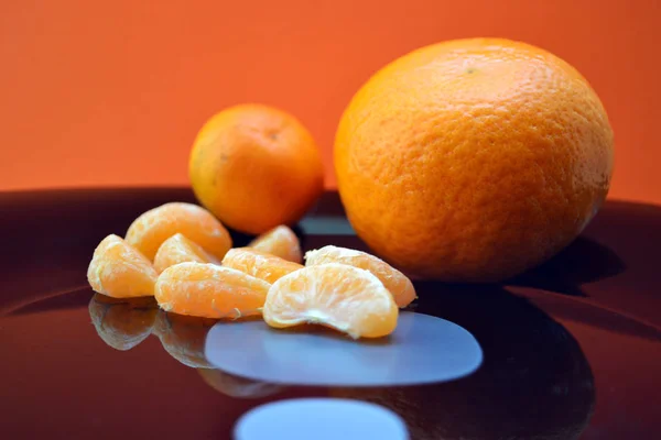 Two mandarins on a black plate — Stock Photo, Image