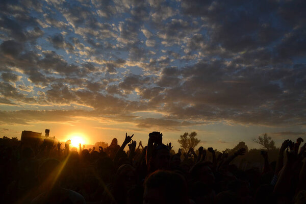 Rock music festival crowd silhouettes at sunset