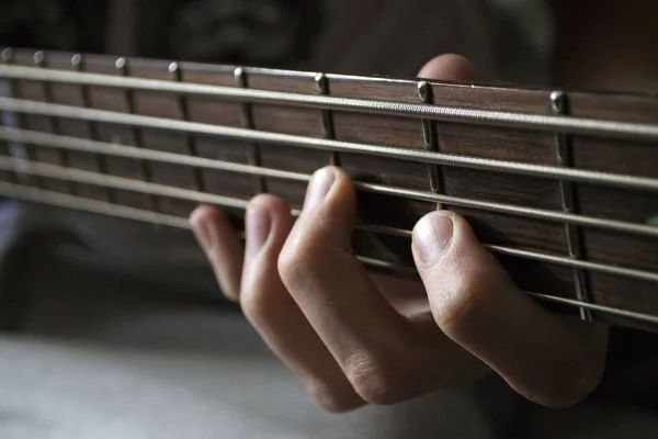 Zbliżenie dłoni na smyczki, gitarzysta basowy — Zdjęcie stockowe