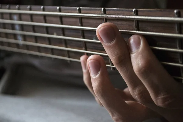 Басовий гітарист, рука на струнах — стокове фото
