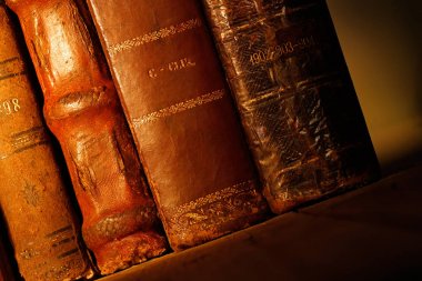 ahşap masa üzerinde eski deri kitaplar