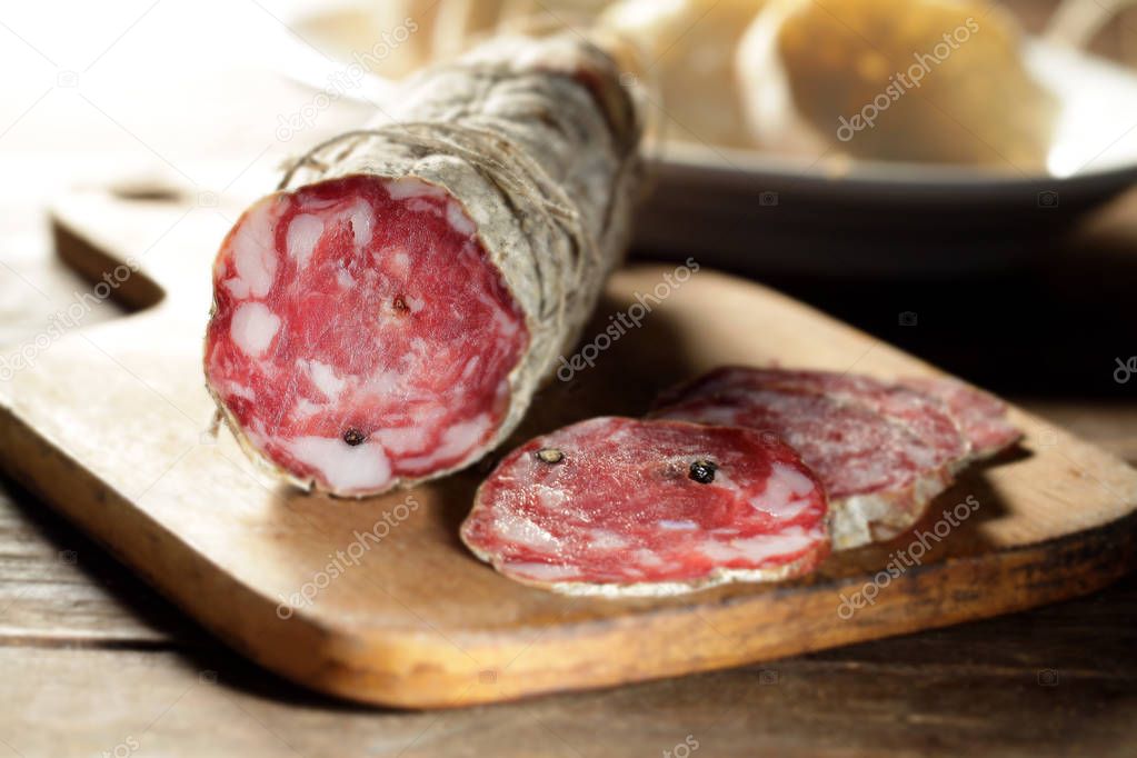 wooden chopping board with sliced pork salami