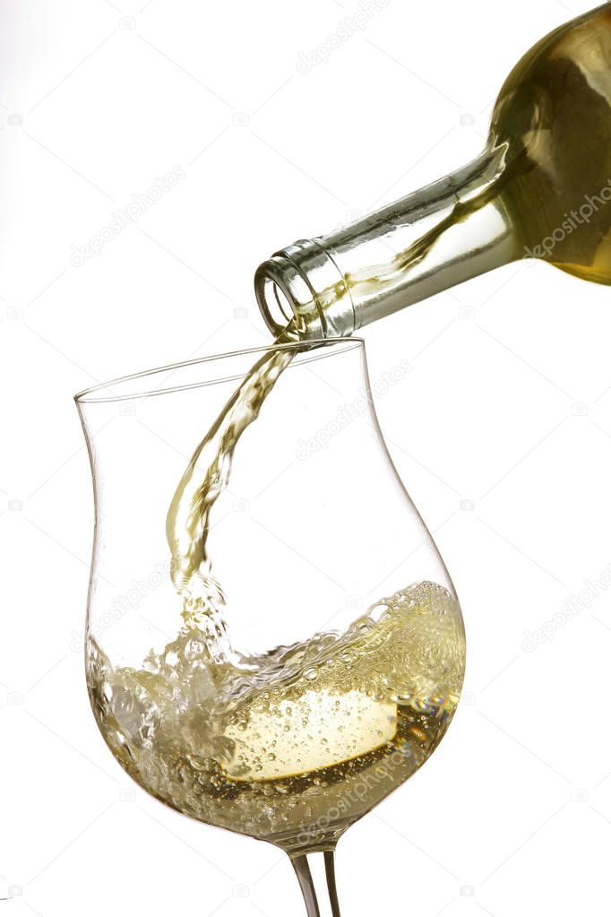 pouring white wine in a transparent glass goblet