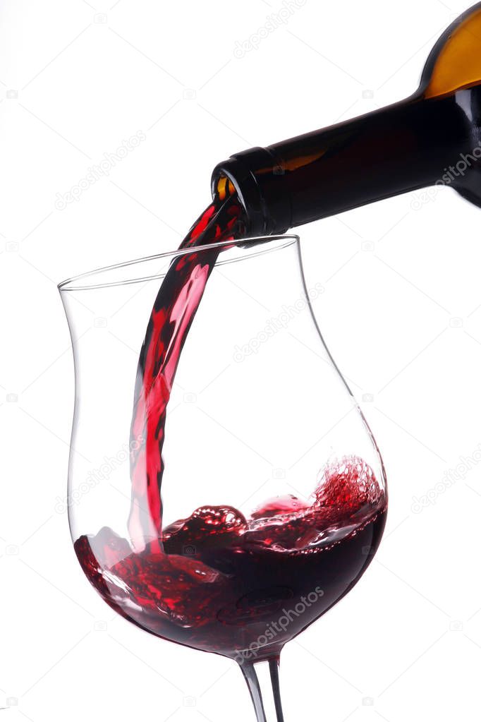 pouring red wine into a transparent glass goblet