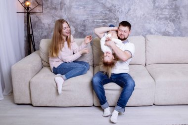 Eğlenceli birlikte evde var genç aile. Anne, baba ve gülüyor, gülüyor ve müzik kız